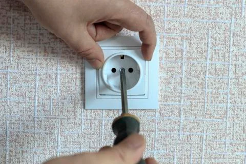 White outlet. the wizard with a screwdriver sets it in place Stock Photos