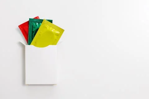 White package with red, green, yellow condoms Stock Photos