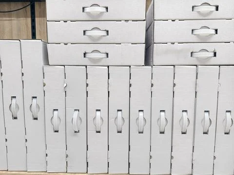 White packaging boxes with handles arranged in straight lines on electronic.. Stock Photos