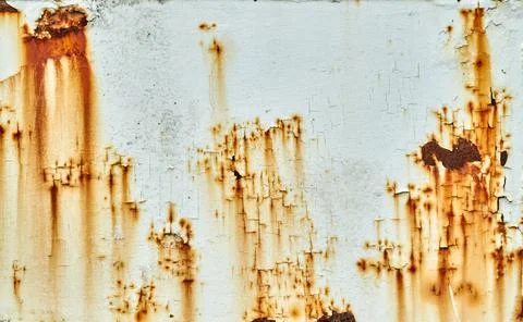 White paint on a metal surface cracks and peels to reveal rust underneath Stock Photos