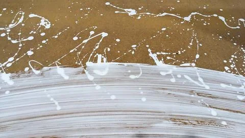 White paint splashes and brush strokes on brown surface abstract background Stock Photos