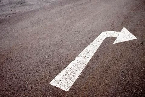 White painted arrow indicating left turn on tarmac surface Stock Photos