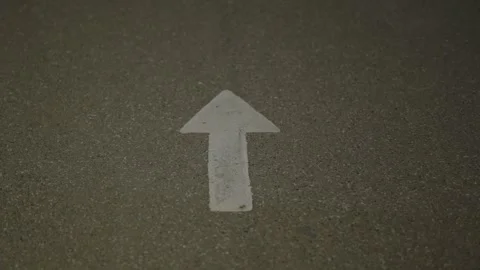 White painted arrow pointing forward on a textured asphalt surface. Stock Footage 342371210