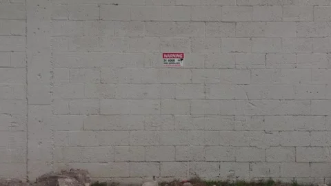 White Painted Cinder Block Wall With Security Warning Sign Outdoors Stock Footage 331622473