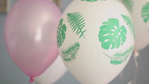 White with palm leaves pattern and pink air balloons' close up Stock Footage 202213671