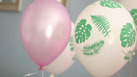 White with palm leaves pattern and pink air balloons close up panoramic shot Stock Footage 202213712