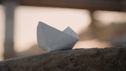 White paper boat resting still life with soft lighting and textured stone Stock Footage 346734071
