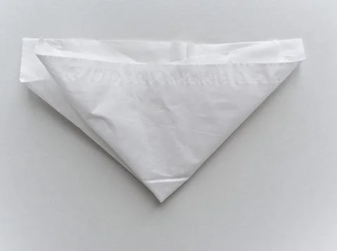 A white paper is folded into a triangle Stock Photos