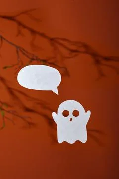 White paper ghost with a bubble for text on an orange background Stock Photos
