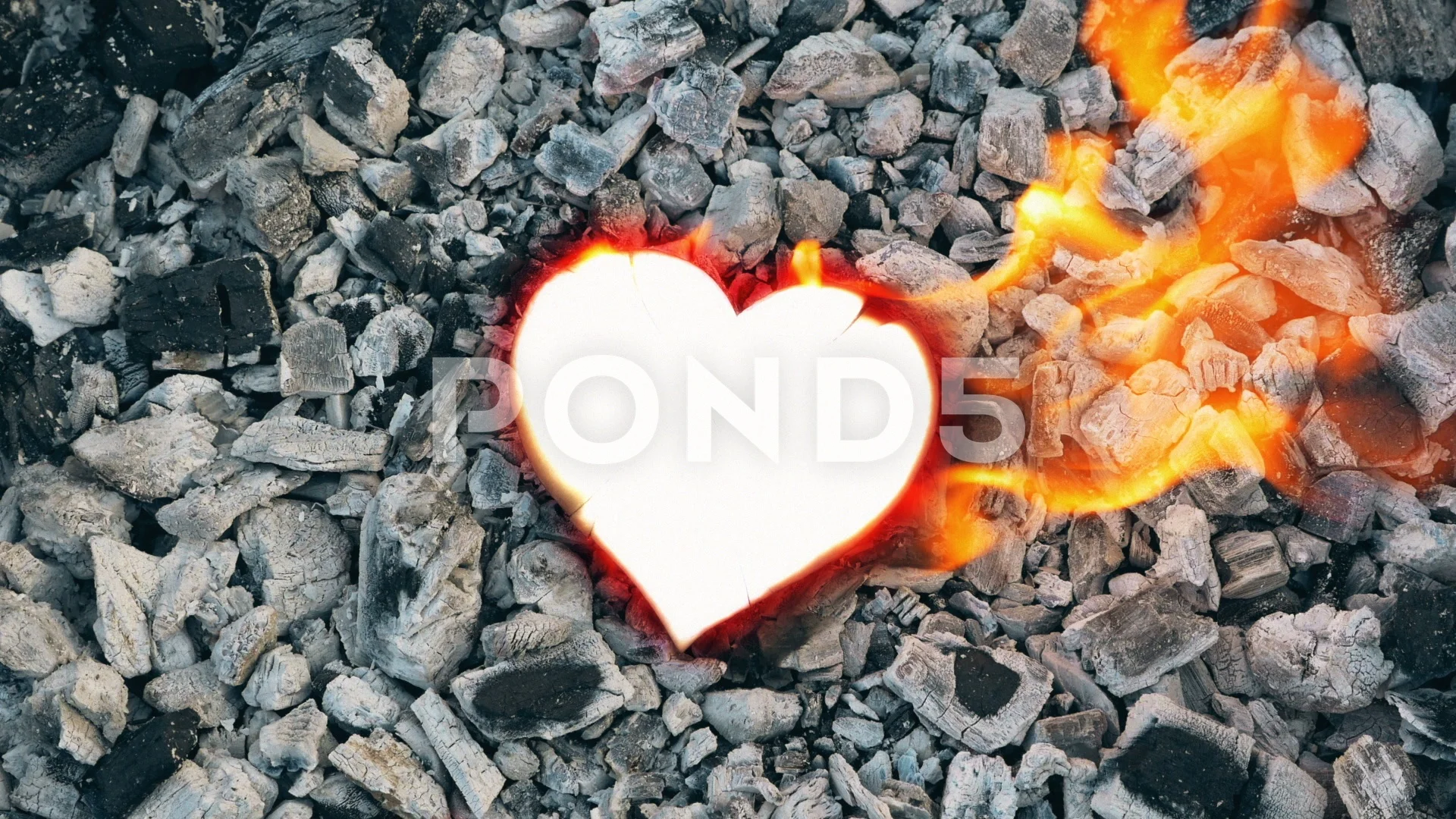 Burned heart-shaped paper isolated on white. Stock Photo by