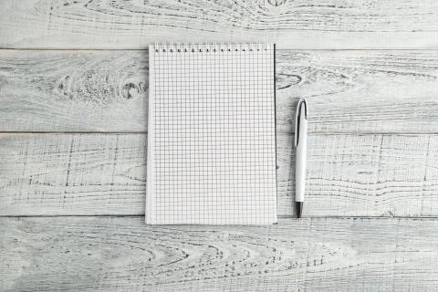 White paper Notepad and white pen on vintage shabby white wooden background Stock Photos