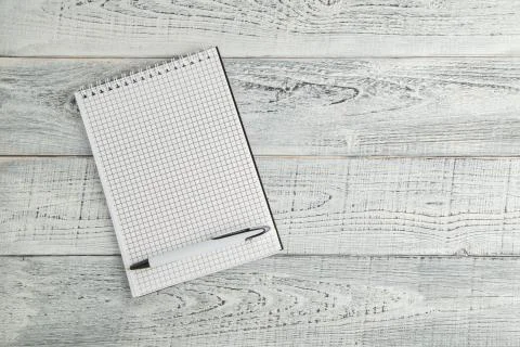 White paper Notepad and white pen on vintage shabby white wooden background Stock Photos