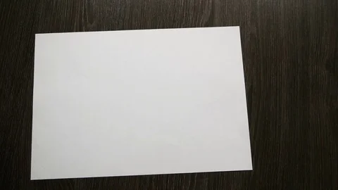 White paper for notes falls on a dark wooden table. Slow motion Video stock 84593791