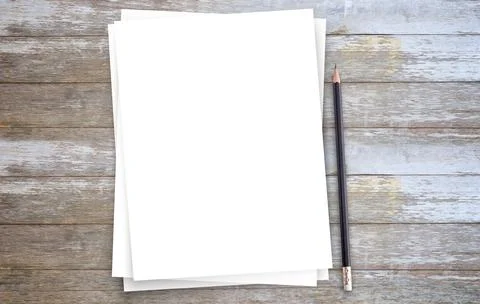 White paper or notepad with pencil on brown wood table background. Stock Photos