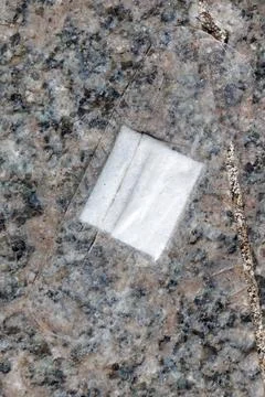 White paper patch rests on speckled granite surface Stock Photos