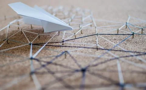 White paper plane over the threads linking the nails. Entities connected.  Stock Photos