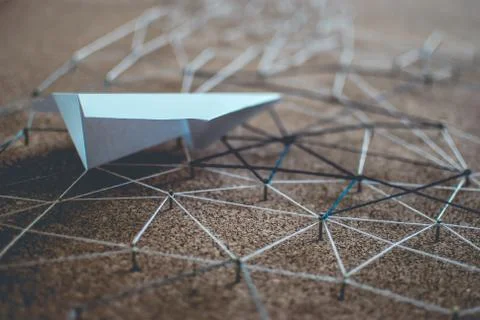White paper plane over the threads linking the nails. Entities connected.  Stock Photos