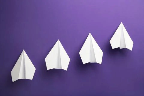 White paper plane on violet background, Business competition concept. Stock Photos