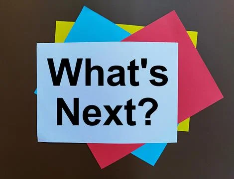 White paper on several layers of colored paper written whats next Stock Photos