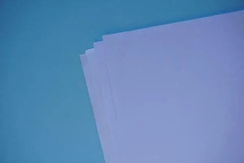 White paper sheets on blue surface. Office Minimalism Concept background. Fla Foto stock