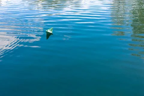 White paper skiffs float on water. Origami. Stock Photos