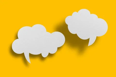 White paper in speech bubble shape set against yellow background. Stock Photos