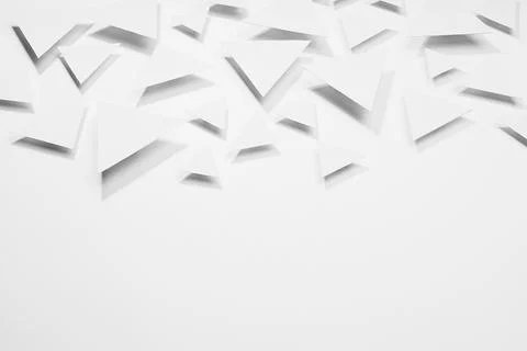 White paper triangles different size soar as abstract random pattern in brigh Stock Photos