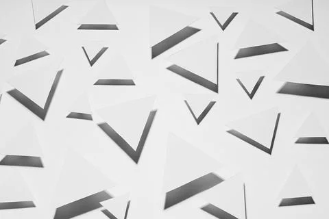 White paper triangles different size as abstract random pattern in bright lig Stock Photos