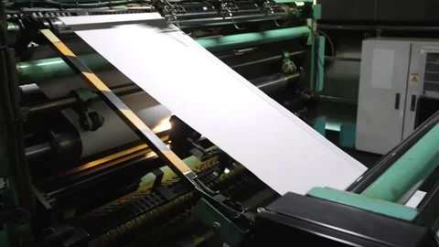 White paper web sheets passing at high speed through green guide rollers and Stock Footage 337889509