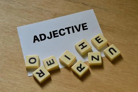 White paper written with text ADJECTIVE over wooden background. Stock Photos