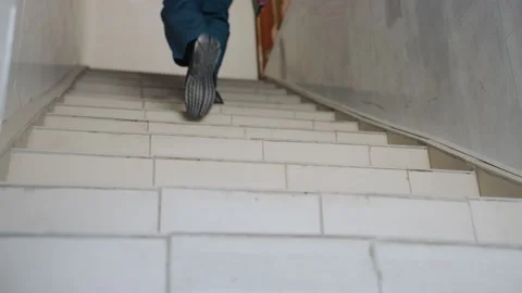 White paramedic running up tiled stairs, fast pace, heavy boots, narrow corridor Video stock 342336971