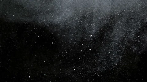 White particles and ink slowly moving in water on black background Stock Footage
