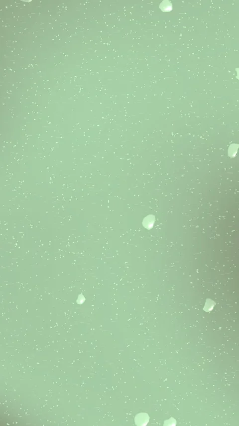 White Particles Floating Slowly in Soft Green Liquid Background 動画素材 333985210