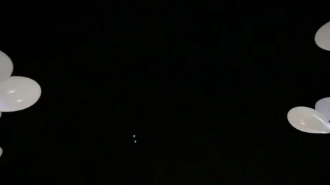 White party baloons fly to dark night sky Video stock 75191791