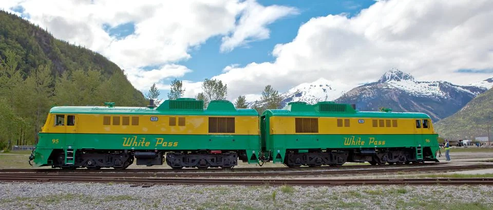 White Pass train parked in front of mountain range Stock Photos