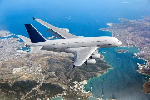 White passenger double decker plane fly over the sea Stock Photos
