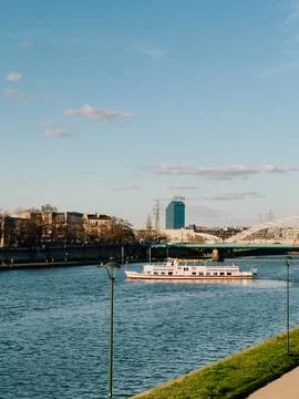 White passenger ferry sailing on Vistula river in Krakow with Grunwaldzki bridge Stock Photos