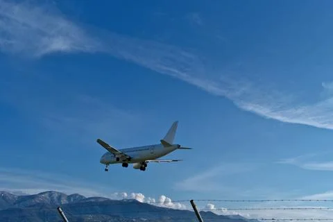 White passenger plane on final approach on a sunny day with blue sky Stock Photos