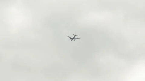 White passenger plane flies in cloudy sky. unmarked aircraft in sky, viewed from Stock Footage 235491300