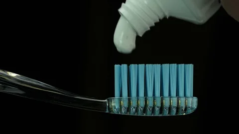 A white paste is squeezed onto a transparent toothbrush Stock Footage 127115477