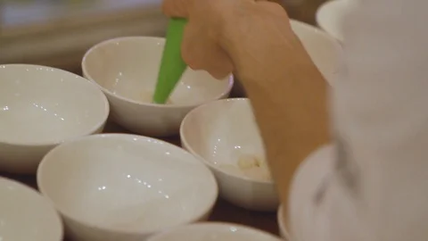 White Pasting Coming Out Of A Squeeze Bag Into Bowls Stock Footage 127179975