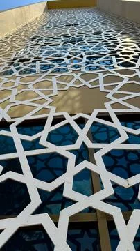 White patterned metalwork against building facade creates striking geometric  Stock Photos