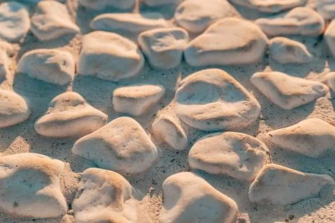 White pebble stone walkway texture bathed in golden hour light. Concept of .. Fotos Stock