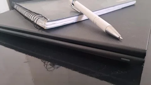 White pen resting on black laptop video motion surface background Stock Footage 339739856