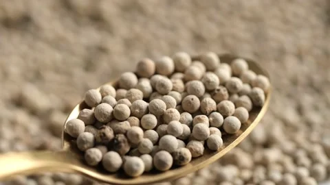 White pepper in golden spoon and peppercorn on background. Flavorful and Stock Footage 195159873