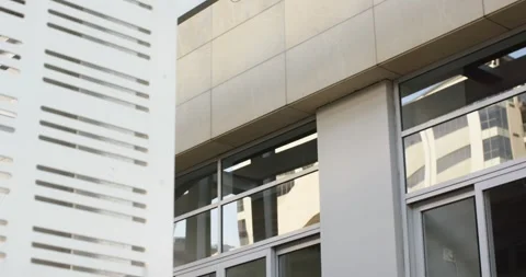 White perforated panel appearing on left and sliding across facade covering Stock Footage 317838572