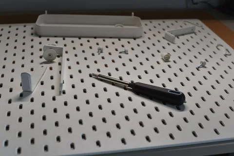 White perforated pegboard with modular organization accessories screwdriver Foto stock