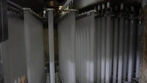 White phosphor coated glass tubes suspended in rows during the coating stage of Stock Footage 341661116
