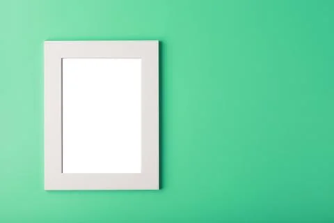 White photo frame with an empty space on a green background. Stock Photos