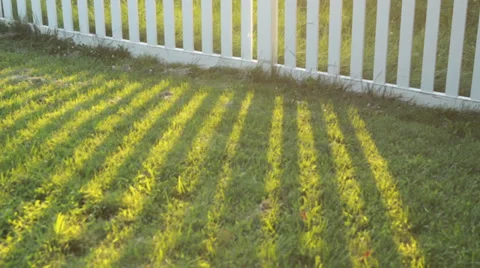 White picket fence casting shadow Stock Footage
